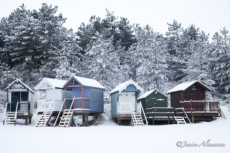 LSn767112 A Curve of Colourful Beach Huts brightens the Snow